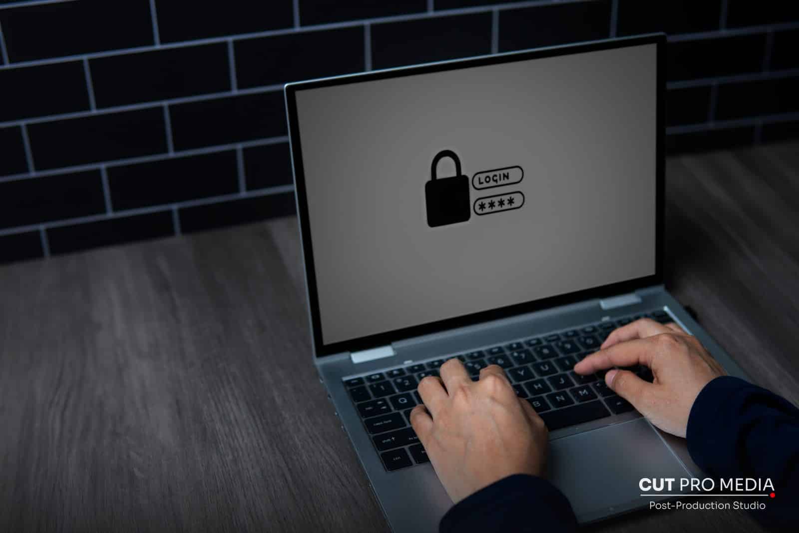 Laptop showing a padlock login screen while someone types