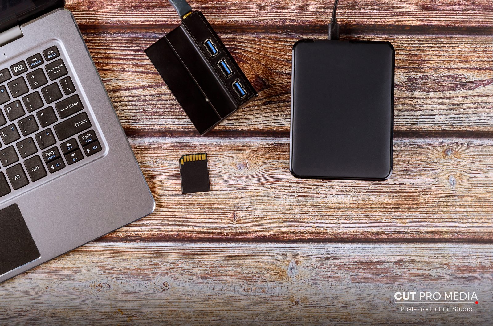 Laptop with external drives, card readers and memory cards on a desk