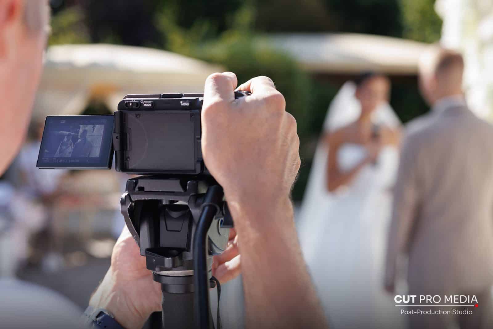 Wedding videographer filming the bride and groom with a camcorder