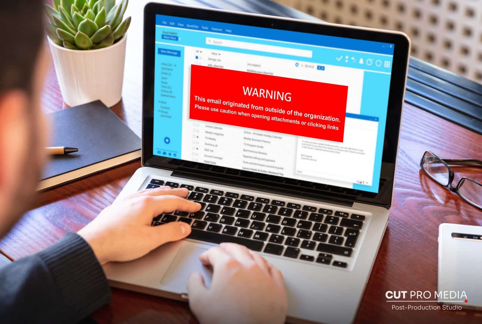 Laptop showing an email warning while someone types